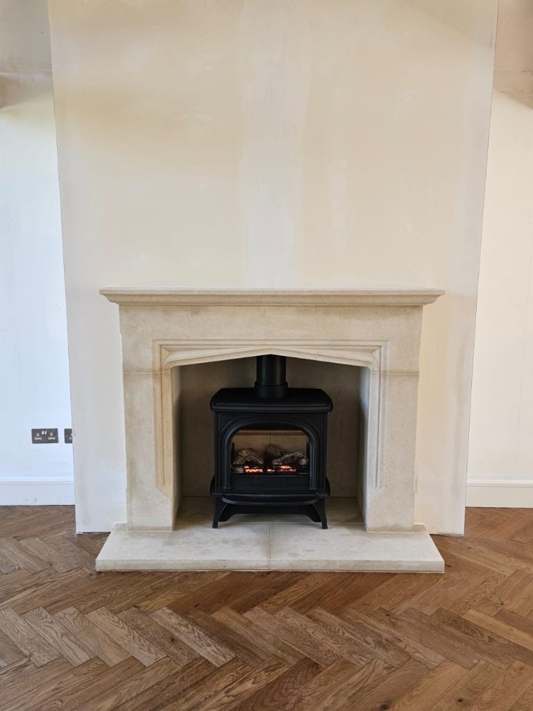 Huntingdon 40 balanced flue gas stove fitted within a bespoke Bath Stone fireplace in Surrey