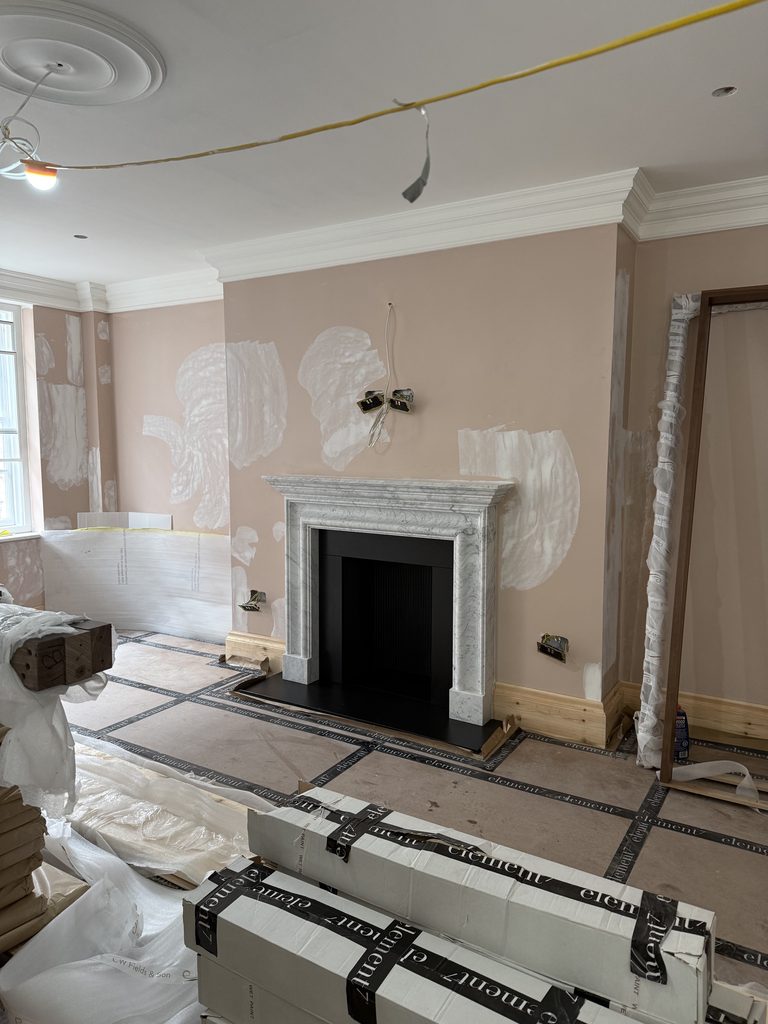Bespoke honed Carrara marble fireplace installed in a Mayfair apartment