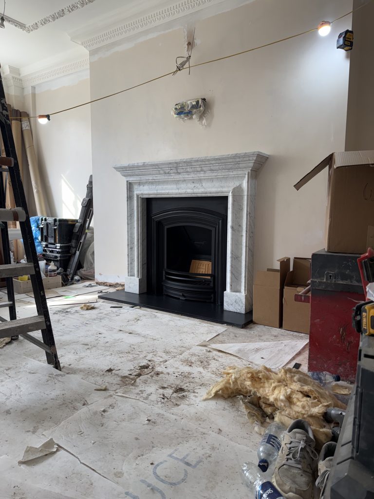 Honed Carrara marble fireplace with Stovax Edwardian cast iron insert in Mayfair